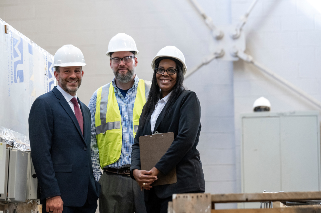 three people in hard hats looking at camera