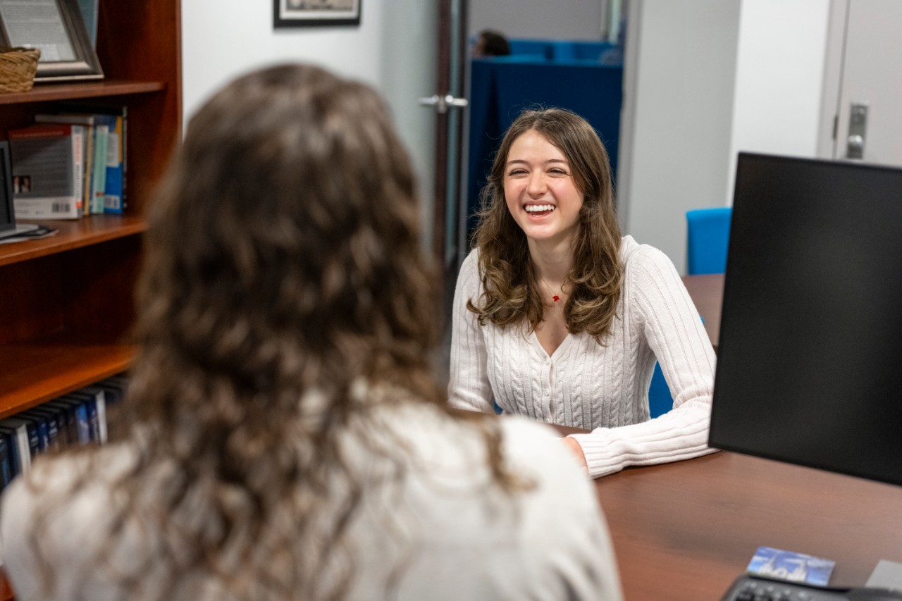 Student speaking to a staff member in an office in the Career Center.