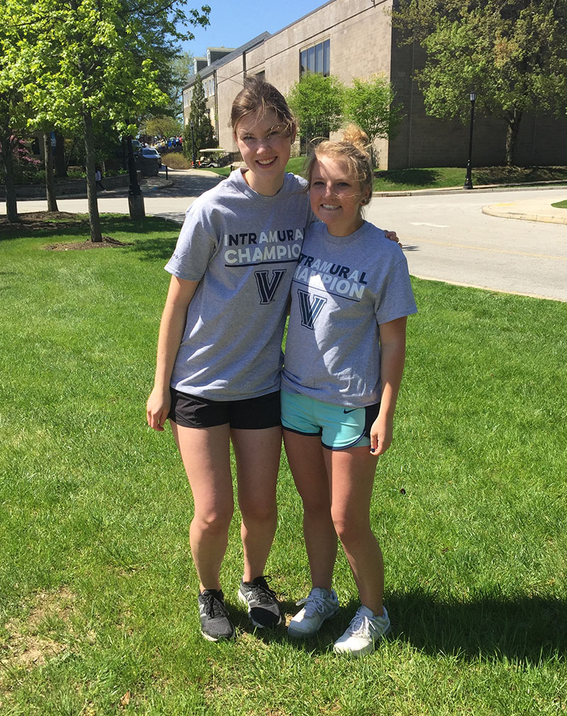 Two female students posing for doubles tennis champion photo