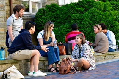 Humanities alumni and faculty chat outside at the Convivium retreat.