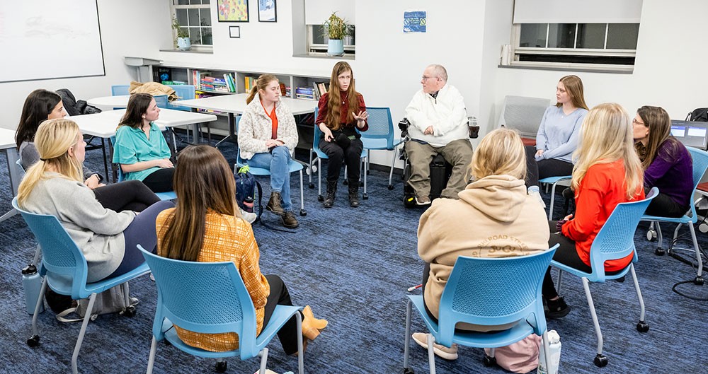 small focus group of people sitting in a circle in chairs in a classroom small focus group of people sitting in a circle in chairs in a classroom