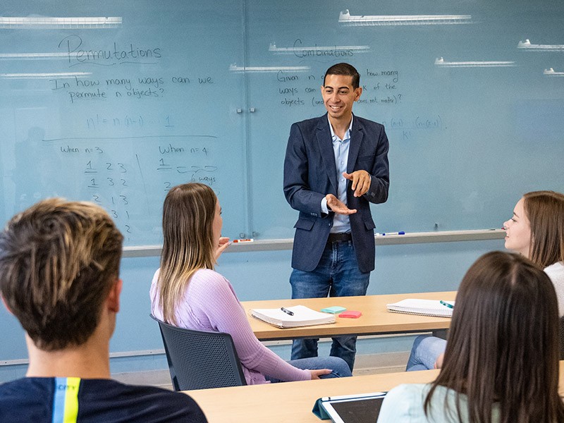 Alexander Diaz-Lopez, PhD, teaches about permutations at the front of a classroom.