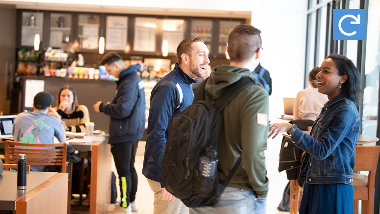 Several students are having conversation inside of the cafeteria