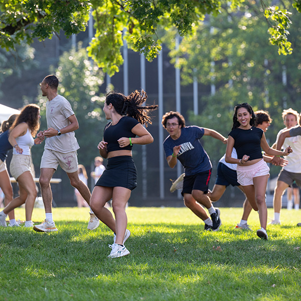 A group of Villanovans run around outside playing a game.
