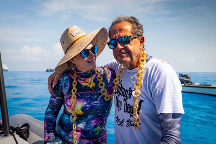 Carl Allen and his wife Gigi on a boat with a massive gold chain around their necks